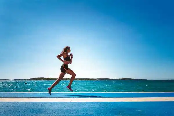 Woman running showing strong leg muscle Ware